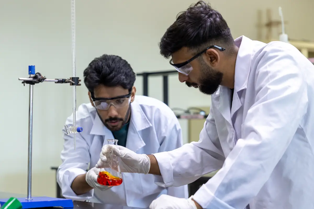 Two students in lab coats running an experiment at UTB.