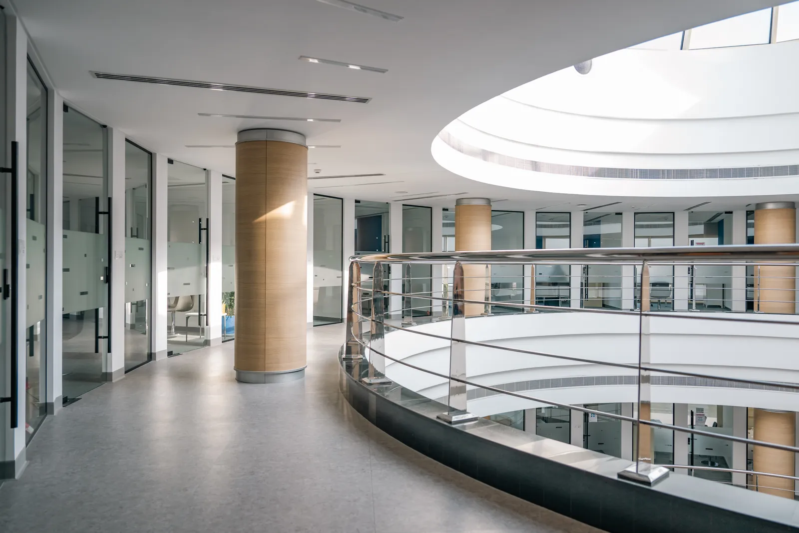 The daylit central atrium at UTB, with a curved balcony and a circular skylight.