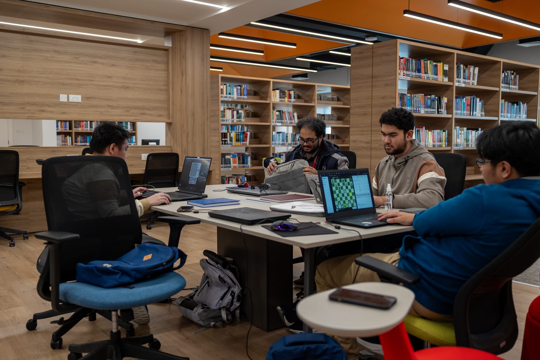 Students working together on laptops in the University of Technology Bahrain library