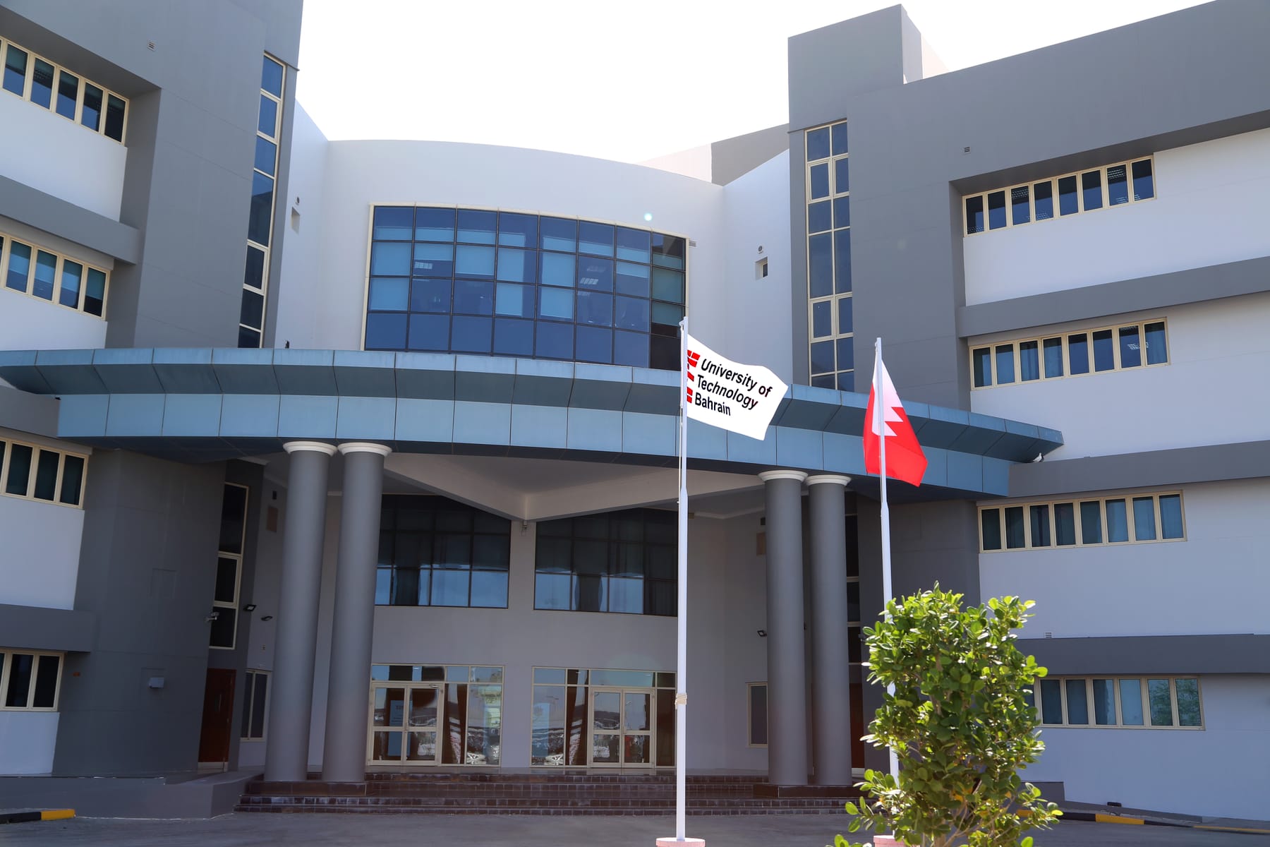The University of Technology Bahrain campus entrance with the Bahrain national flag